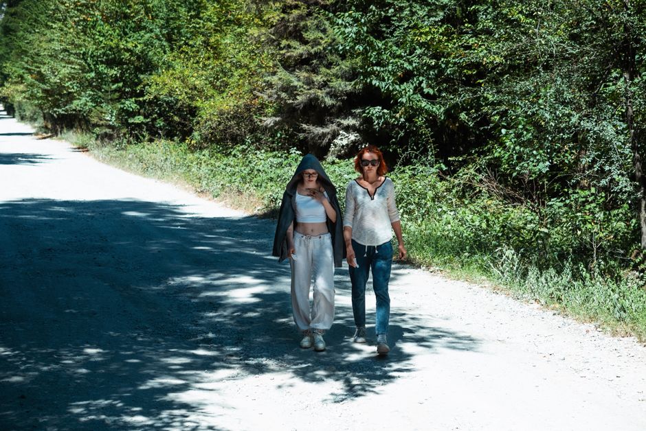 A peaceful walk in the forest showcasing friendship and leisure in a serene setting.