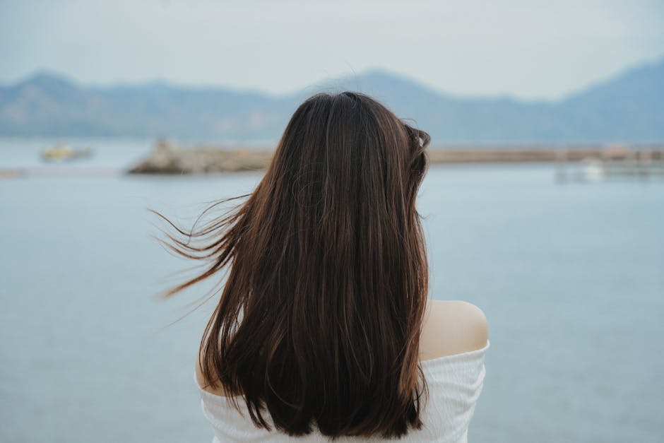 A serene image of a woman facing the ocean at a beach in Shenzhen, China during summer.