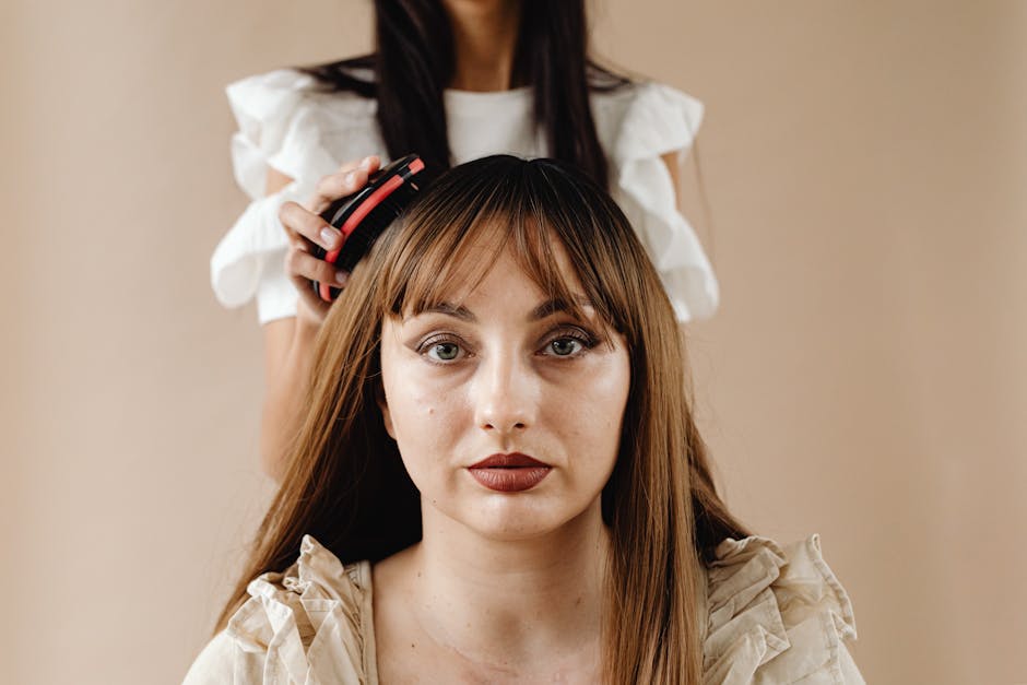Close-up of a woman getting her hair styled by another person, focusing on beauty and care.