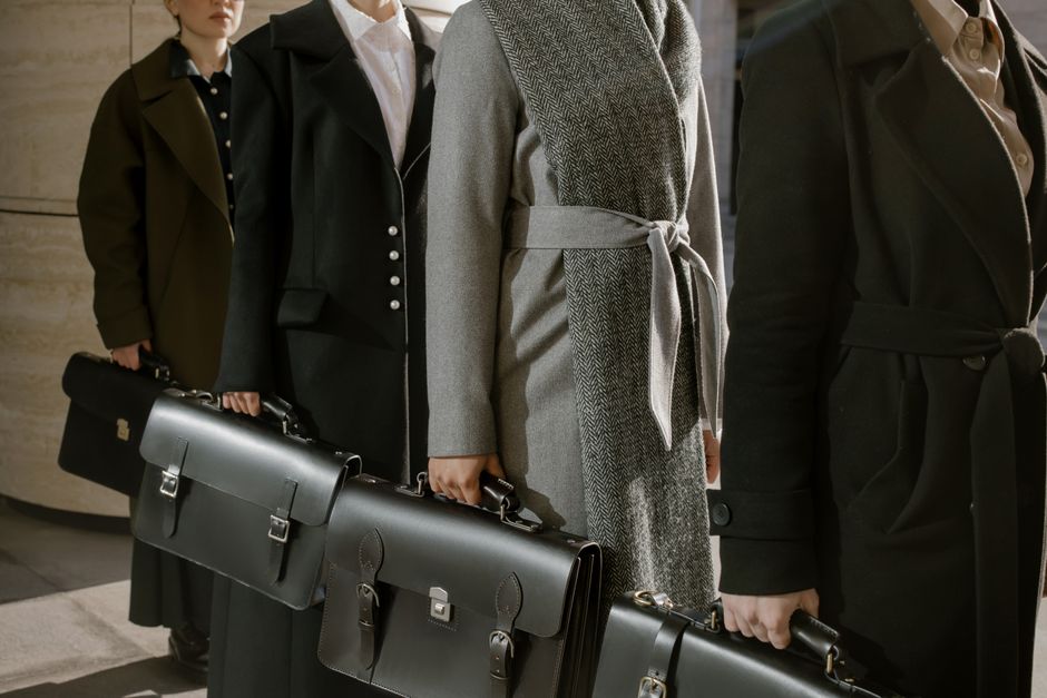 A group of professionals in coats holding briefcases, ready for business.
