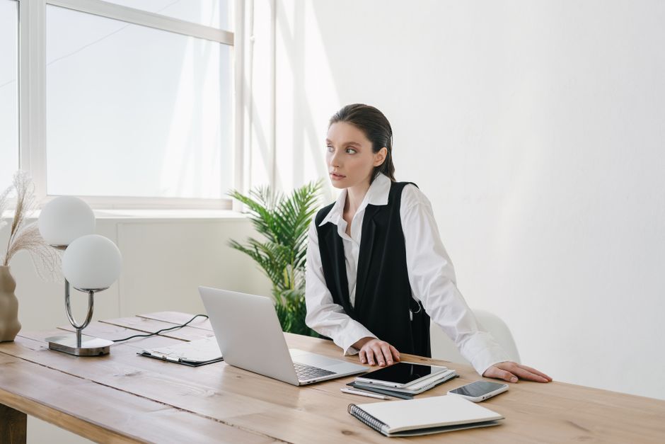 Businesswoman working at a laptop in a bright, contemporary office space.